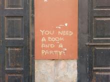 Street art: text-only graffito saying "You need a book and a party"