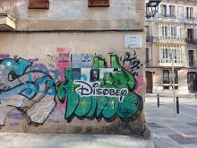 Street art: text "Disobey" in style of the Disney logo.