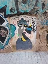 Street art: badger with prominent tail in various colors.