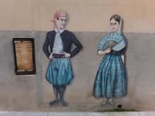 Street art: Two spaniards, possible male and female, facing at each other.