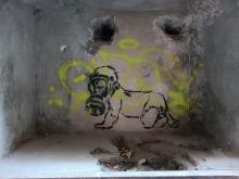 Street art: a crawling baby wearing a gas mask